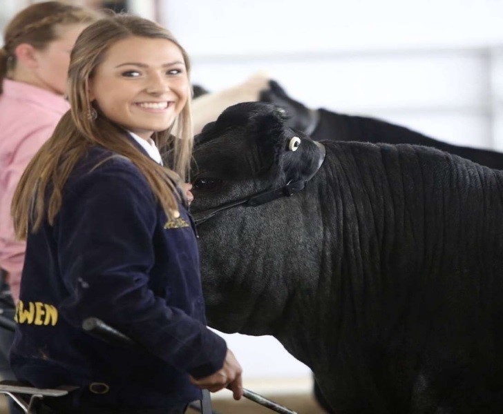 Student smiles with her cow